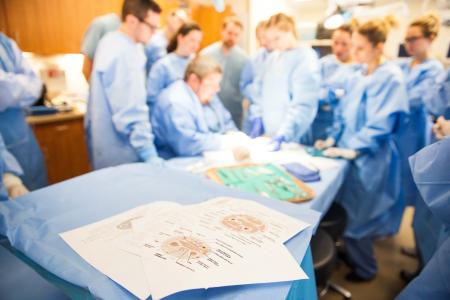 Doctors and nurses in blue gowns reviewing charts