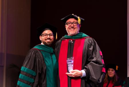 Image of Dr. Jacob Ribbing presenting Dr. Matt McQuillan with an award